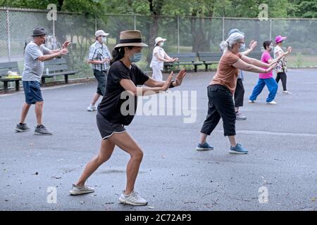 Mit richtigen sozialen Distanzierung & Masken tragen, eine Gruppe von Männern und Frauen Tai Chi üben. In Kissena Park, Flushing, New York City. Stockfoto