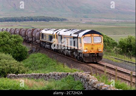 Ein abendlicher Güterzug, der von zwei Diesellokomotiven der Klasse 66 gezogen wird, fährt nach Norden nach Carlisle, Blea Moor, Settle-Carlisle Railway, North Yorkshire, UK Stockfoto