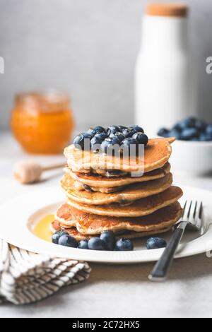 Pfannkuchen mit Heidelbeeren und Honig auf einem Teller. Leckere Pfannkuchen. Getöntes Bild Stockfoto