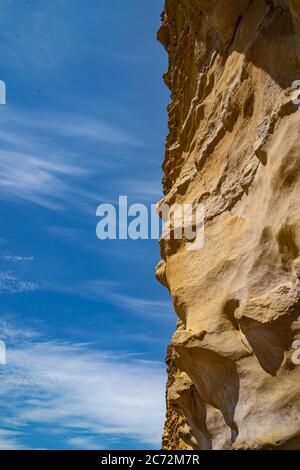 Meeresklippen bei Burton Bradstock, dem Beginn des Chesil-Strandes, an der Jurassic Coast von Dorset, Großbritannien mit blauem Himmel und weißen Wolken Stockfoto