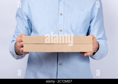 Mann, der Pappkartons mit Pizza hält. Pizzalieferung. Lieferung per Kurier nach Hause. Stockfoto