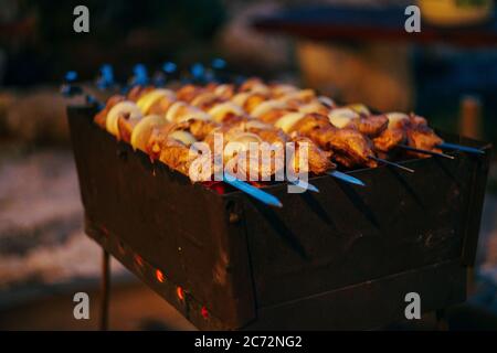 Ein Schweinefleisch auf dem Grill im Frühlingsgarten. Kochen Schaschlik auf dem mangal in der Natur. Schaschlik Kochen auf den Kohlen Stockfoto