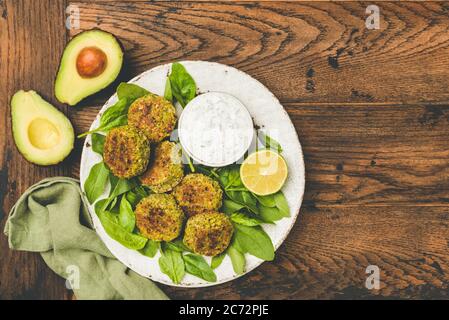 Spinat Avocado Falafel mit Joghurt Dip Sauce auf Holztisch. Kopiespeicher in der Draufsicht Stockfoto