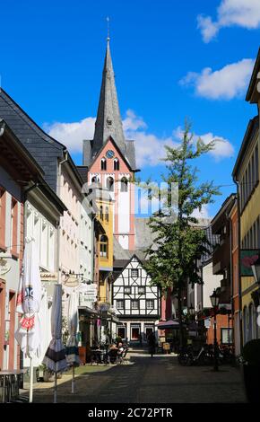 Kempen, Deutschland - 9. Juli. 2020: Blick über die Fußgängerzone auf das weiße mittelalterliche Fachwerkhaus mit katholischem Kirchturm im Sommer mit blauem Himmel Stockfoto