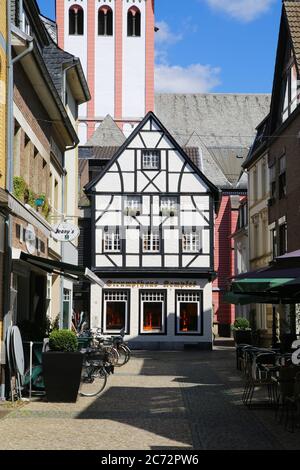 Kempen, Deutschland - 9. Juli. 2020: Blick über die Fußgängerzone auf das weiße mittelalterliche Fachwerkhaus mit katholischem Kirchturm im Sommer mit blauem Himmel Stockfoto