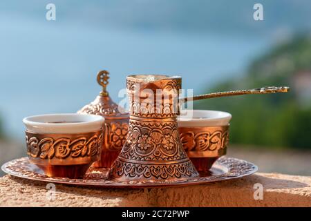 Traditioneller schwarzer bosnischer Kaffee in schöner Kupferkeuze am Holztisch Stockfoto