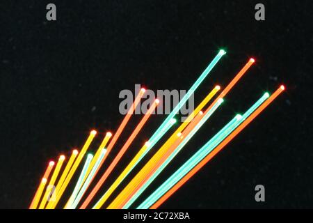Nahaufnahme eines Makroes einer bunten Gruppe von Lichtwellenleitern auf schwarzem Hintergrund. Stockfoto