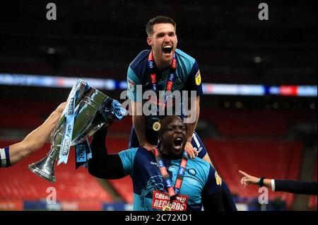 Adebayo Akinfenwa (unten) von Wycombe Wanderers feiert mit der Trophäe nach dem Gewinn des Play-off-Finales der Sky Bet League One im Wembley Stadium, London. Stockfoto