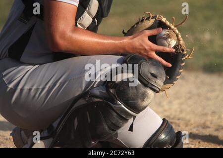 Ein Baseballfänger bewältigt ein Spielfeld. Stockfoto