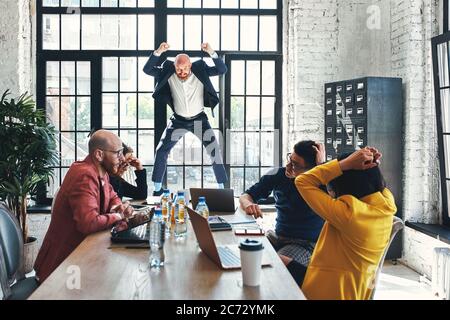 Wütend anzuschreien seine Arbeiter mit einem ausdrucksstarken Look Geschäftsmann Stockfoto