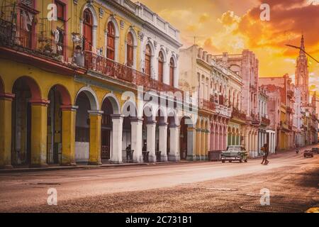 Straßenszene mit Oldtimer und bunten Gebäuden in Havanna bei Sonnenuntergang Stockfoto