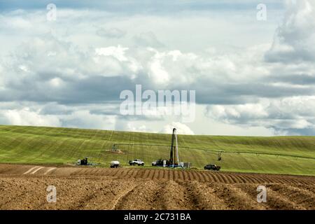 Ein Bohrgerät, das in einem Idaho-Farmfeld eingerichtet wurde, um einen Wasserbrunnen zu bohren, um Bewässerungswasser zu den Farmfeldern zu liefern. Stockfoto