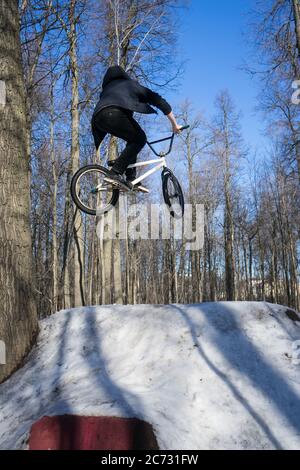 bmx-Fahrer macht einen Dirt-Jumping-Trick im Winter. Moto Whip auf bmx Stockfoto