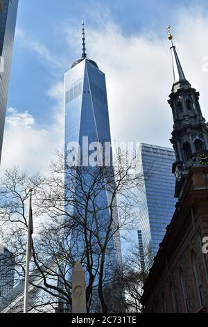 One World Trade Center von einem Baum aus gesehen und die Spitze der St. Pauls' Kapelle am Broadway in Lower Manhattan, New York City. Stockfoto