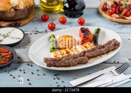 schisch-Fleischbällchen aus der türkischen Küche. Serviert mit weißem Teller auf Holztisch. Stockfoto