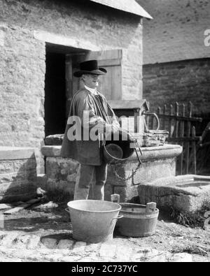 1920ER JAHRE REIFER MANN HÄLT EIMER GUT TRAGEN TRADITIONELLE TRACHT EINES LANDMANNS ODER LANDWIRT VON BRETON BRETAGNE FRANKREICH - C3967 HAR001 HARS GESCHICHTE ÄLTERE LÄNDLICHE HEIMAT LEBEN KOPIEREN RAUM HALBE LÄNGE PERSONEN TRADITIONELLE CHARAKTER LANDWIRTSCHAFT MÄNNER EUROPA MITTLEREN ALTERS LANDWIRTSCHAFT B & W MITTLEREN ALTERS MANN GLÜCK ALTER OLDSTERS FRÖHLICHER OLDSTER EIMER STOLZ LOKALEN BERUFE LÄCHELT ÄLTESTEN FREUDIGEN KITTEL STILVOLLE ODER BRETAGNE EIMER SCHWARZ UND WEISS KAUKASISCHEN ETHNIZITÄT HAR001 ALTMODISCHE REGIONALE Stockfoto