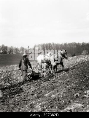 1920ER JAHRE BAUERNHOF MANN JUNGE ZU FUSS ENTLANG BRECHEN KLUMPEN ANONYM LÄNDLICHEN LANDWIRT VATER SINGLE PFLÜGEN MIT ZWEI PFERDEN MARYLAND USA - F2199 HAR001 HARS JUGENDLICH STIL PFERDE TEAMARBEIT SÖHNE FREUDE LIFESTYLE ZUFRIEDENHEIT LÄNDLICHEN HAUSLEBEN VEREINIGTE STAATEN KOPIEREN RAUM FREUNDSCHAFT GANZKÖRPERMENSCHEN INSPIRATION VEREINIGTE STAATEN VON AMERIKA LANDWIRTSCHAFT MÄNNER VÄTER FÜHRENDE LANDWIRTSCHAFT B&W MORGEN NORDAMERIKA ZIELE NORDAMERIKA BRECHEN SÄUGETIERE HOHEN WINKEL FRÜH UND ENTLANG VÄTER AUSSEN BAUERN PFLÜGEN STOLZ BEGINNEN RÜCKANSICHT BERUFE VERBINDUNG VON HINTEN ENTWURF ANONYME SPLIT-RAIL RÜCKANSICHT GEZÜCHTET JUGENDLICHE Stockfoto