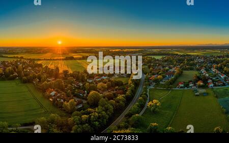 Sonnenuntergang über einer kleinen Stadt, orange Sonnenstrahlen beleuchten die Häuser. Schöne Zeit eines springday. Stockfoto