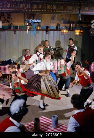 1960S 1970S FESTLICH TIROLER GEKLEIDET KOSTÜMIERTE TÄNZER IN EINEM BIERSAAL MIT MUSIKERN FRAUEN SPINNEN MÄNNER KNIEN - KD3082 PHT001 HARS WILLKOMMEN KOMMUNIKATION TROPISCHE KARRIERE JUNGE ERWACHSENE BALANCE COMIC TEAMWORK FREUDE LIFESTYLE SCHAUSPIELER FEIER FRAUEN SPINNEN JOBS LÄNDLICHE KOPIE RAUM FREUNDSCHAFT GANZKÖRPERSCHAFT DAMEN KÖRPERLICHE FITNESS PERSONEN INSPIRATION TRADITIONELLE MÄNNER BERUF UNTERHALTUNG VERTRAUEN MUSIKER MITTLEREN ALTERS MANN KNIEEND DARSTELLENDE KÜNSTE GESCHICKLICHKEIT HUMORVOLLE BESCHÄFTIGUNG GLÜCK FÄHIGKEITEN AKKORDEON HIGH ANGLE ABENTEUER ENTDECKUNG PERFORMER STÄRKE KUNDENDIENST KARRIERE AUFREGUNG ERHOLUNG Stockfoto