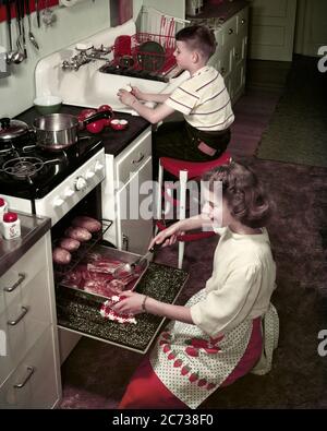 50S KÜCHE LÄCHELND TEENAGER MÄDCHEN SCHWESTER KNIET DURCH BACKOFEN RÖSTEN KOTELETTS BACKEN KARTOFFELN JUNGE BRUDER GESCHIRR WASCHEN AM WASCHBECKEN - KF38904 FRT001 HARS NOSTALGIE BRUDER ALTE MODE SCHWESTER 1 JUGENDLICH TEAMWORK KARTOFFELN LIFESTYLE CHORES FRAUEN BRÜDER MODERNES HEIM LEBEN KOPIEREN RAUM VOLLER LÄNGE HALBLÄNGE PERSONEN WASCHBECKEN INSPIRATION MÄNNER TEENAGER MÄDCHEN GESCHWISTER VERTRAUEN SCHWESTERN KNIEND GLÜCK HIGH WINKEL STÄRKE UND VORBEREITUNG BEI DURCH IN GESCHWISTER KONZEPTIONELLE STILVOLLE TEENAGED KOTELETTS ZUSAMMENARBEIT WACHSTUM JUVENILES PRE-TEEN PRE-TEEN JUNGE RÖSTUNG ZWEISAMKEIT KAUKASISCHE ETHNIE ALTMODISCH Stockfoto