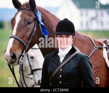 70ER JAHRE PORTRAIT LÄCHELNDES TEENAGER MÄDCHEN IM REITSPORT OUTFIT HELM BLICK AUF KAMERA STEHEN VON DUNKELBRAUNEM PFERD MIT BLAUEM BAND - KH7306 PHT001 HARS GESICHTS PFERDE SICHERHEIT TEAMWORK WETTBEWERB ATHLET BRAUN FREUDE LIFESTYLE ZUFRIEDENHEIT FRAUEN LÄNDLICHE GESUNDHEIT LUXUS KOPIEREN RAUM FREUNDSCHAFT HALBE LÄNGE PERSONEN GEWINNER INSPIRATION TEENAGER MÄDCHEN ATHLETISCHES OUTFIT TRANSPORT AUSDRÜCKE AUGENKONTAKT GLÜCK SÄUGETIERE ABENTEUER FREIZEIT STOLZ STILVOLLE TEENAGED DRESSUR ZUSAMMENARBEIT JUGENDLICHE SÄUGETIERE ZWEISAMKEIT KAUKASISCHE ETHNIE REITEN ALTMODISCH Stockfoto