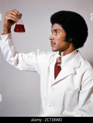 1970ER PROFIL PORTRÄT VON PROFESSIONELLEN AFROAMERIKANISCHEN MANN IM LABORMANTEL HALTEN BIS PRÜFUNG GLASBECHER DER CHEMISCHEN FLÜSSIGKEIT - KL6377 HAR001 HARS HALBE LÄNGE PERSONEN INSPIRATION AFRO MÄNNER BERUF VERTRAUEN ERFOLG GESCHICKLICHKEIT BERUF FÄHIGKEITEN ENTDECKUNG UNIVERSITÄTEN CHEMIKER AFRO-AMERIKANER AFRO-AMERIKANISCHE BEAKER KARRIERE PRÜFUNG FRISUR WISSEN SCHWARZE ETHNIZITÄT STOLZ IN DER CHANCE AUF AUTORITÄT BERUFE HIGH-TECH-HOCHSCHULBILDUNG KONZEPTIONELLE STILVOLLE HOCHSCHULEN MID-ADULT MID-ADULT MANN STUDIOUS JUNGEN ERWACHSENEN MANN HAR001 ALTMODISCHEN AFROAMERIKANER Stockfoto