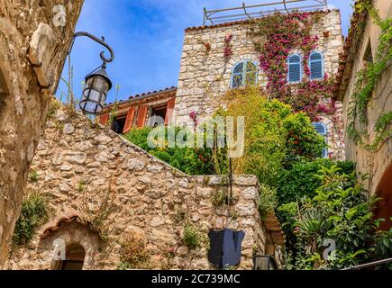 Steinaußenseite alter Gebäude mit Blumen in den Straßen von Eze Village, malerischer Mittelalterstadt in Südfrankreich entlang des Mittelmeers Stockfoto