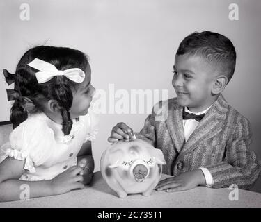 60S SMILING AFRICAN-AMERICAN BOY AND GIRL PUTTING MONEY INTO PIGGY BANK - N1740 HAR001 HARS TEAMWORK FREUDE FREUDE LIFESTYLE ZUFRIEDENHEIT FRAUEN BRÜDER STUDIO ERSCHOSSEN HEIM LEBEN KOPIEREN RAUM FREUNDSCHAFT HALBE LÄNGE INSPIRATION BANKING MÄNNER GESCHWISTER SCHWESTERN B&W FINANZIELLE ZIELE ANZUG UND KRAWATTE TRÄUME GLÜCK FRÖHLICHE STRATEGIE AFRO-AMERIKANER AFRO-AMERIKANER UND AUFREGUNG SCHWARZ ETHNIZITÄT GESCHWISTER LÄCHELT VERBINDUNG KONZEPTIONELL FREUNDLICH FRÖHLICH STYLISH UNTERSTÜTZUNG FLIEGE ZUSAMMENARBEIT WACHSTUM JUVENILES ZÖPFE ZWEISAMKEIT SCHWARZ UND WEISS HAR001 ALTMODISCHE AFROAMERIKANER Stockfoto