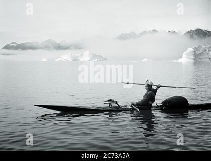 50S MAN GRÖNLANDISCHES INUIT JAGD HARPOONER IN KAYAK AUF SYDKAP IN OSTGRÖNLAND TEIL DES SCORESBY SUND FJORDSYSTEMS - R10265 LUT001 HARS ABENTEUER AUS DEM HOCHWINKEL ÖSTLICHER MUT TEIL GELEGENHEIT INUIT KONZEPTUELLER FJORD INDIANISCHES ARKTISCHES EIS BERGE KAYAK INDIANER PRÄZISION ÜBERLEBEN SCHWARZ-WEISS GRÖNLAND INDIGENE ALT MODISCHER SPEER Stockfoto