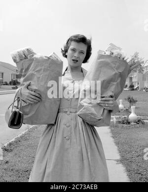 1950ER JAHRE FRAU BESORGT ÄNGSTLICH MÜDE ERSCHÖPFT GESICHTSAUSDRUCK MIT ZWEI BRAUNEN PAPIERTÜTEN VOLLER LEBENSMITTEL - S8671 DEB001 HARS NOSTALGIE ALTE MODE 1 WUT ANGST KOMMUNIKATION JUNGE ERWACHSENE BALANCE SIGNAL SORGE TRAGEN BRAUN LEBENSSTIL VERÄRGERT FRAUEN GROWNUP ZU HAUSE LEBEN KOMMUNIKATION KOPIE RAUM HALBE LÄNGE DAMEN PERSONEN ERWACHSEN SCHWERE GEFAHR KONTEMPLATION B&W TRAURIGKEIT SHOPPER AUGENKONTAKT HAUSFRAU ÜBERARBEITETER SHOPPER HAUSFRAU NACHBARSCHAFT ÄNGSTLICH BEKÜMMERT ERZÜRNT HAUSFRAUEN ERWÄGEN DEB001 UNMUT FEINDSELIGKEIT ÄRGER KOMMUNIZIEREN KONTEMPLATION EMOTION EMOTIONAL IRRITIERT BEDÜRFNISSE Stockfoto