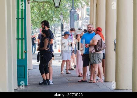 New Orleans, Louisiana/USA - 8. 7. 2020: Touristen Schlange vor dem Cafe Du Monde um sich während des Aufschwungs bei Coronavirus-Fällen zum Mitnehmen zu bringen Stockfoto