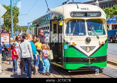 San Francisco California, The Embarcadero, elektrische Straßenbahn, Trolley-Stange, Personenbahn, Bushaltestelle, Boarding, Frau weibliche Frauen, Mann Männer, Jungen, Kind Stockfoto