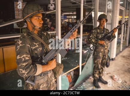 CARACAS, VENEZUELA, MARCH1989 - Soldaten der venezolanischen Armee bewachen den geplünderten Laden während des Ausnahmezustands in Caracas, bekannt als Caracazo. Stockfoto