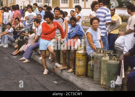 PETARE, CARACAS, VENEZUELA, 1989 - Menschen warten auf die Schlange, um Kochgasbehälter während des Ausnahmezustands nach Protesten, Unruhen und Plünderungen in Caracas, bekannt als Caracazo, aufzufüllen. Stockfoto