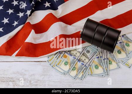 Ein Barrel Öl und hundert Dollar Banknoten Preise auf einer amerikanischen Flagge Hintergrund Stockfoto