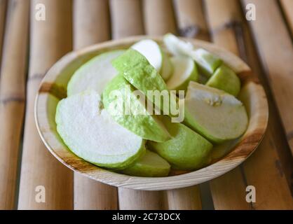 Grüne Guava Obst / Guava Scheibe auf Naturplatte auf Holzhintergrund Stockfoto