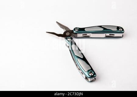 Multitool mit Zange auf weißem Hintergrund. Draufsicht. Werkzeuge zum Schneiden, Sägen, Schrauben, Verdichten und andere. Stockfoto