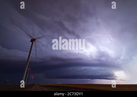 Ein supercell-Gewitter mit dramatischen Wolken am Nachthimmel über einem Windpark in der Nähe von Minneola, Kansas Stockfoto