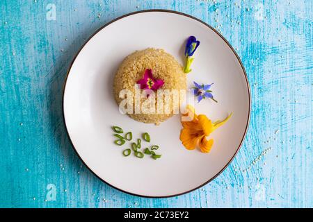 Quinoa-Teller-Präsentation mit essbaren Blumen dekoriert Stockfoto