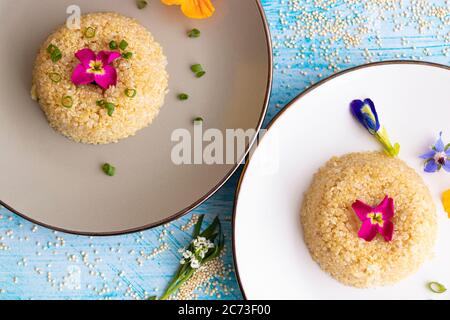 Quinoa-Teller-Präsentation mit essbaren Blumen dekoriert Stockfoto