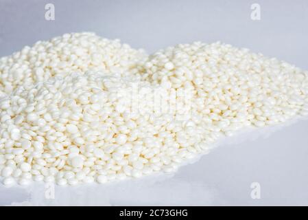 Haufen feiner weißer Polymergranulate liegen auf hellem Hintergrund Stockfoto