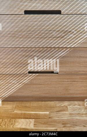 Holzschrank mit Schubladen bei Tageslicht. Moderne Holzmöbel. Holzstruktur. Nahaufnahme Stockfoto