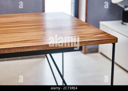 Schreibtisch aus Holz. Schreibtisch aus Nussbaumfurnier mit Metallsockel. Nahaufnahme Stockfoto