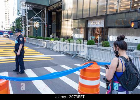 Ein Passant fotografiert ein Wandbild von Black Lives Matter, das auf der Fifth Avenue vor dem Trump Tower in New York gemalt wurde. Als eine von einer Serie von Black Lives Matter Wandmalereien, die in allen fünf Stadtbezirken von New York City gemalt werden, zieht Touristen und Demonstranten auf beiden Seiten der politischen Bewegung an. Stockfoto