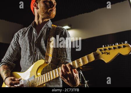 Rock and Roll. Professioneller Musiker spielen elektrische Gitarre im Studio. Schöner Kerl mit Bart üben im Aufnahmestudio Stockfoto