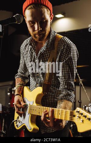 Schöner kaukasischer Kerl genießen E-Gitarre spielen im Aufnahmestudio, er praktiziert vor dem Konzert. Professioneller Musiker führen Musik. Rock Stockfoto