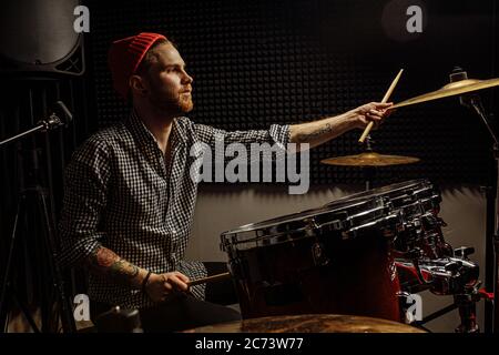 Junge kaukasische talentierte Mann emotional spielen die Trommeln, er liebt und genießen das Spielen auf Instrumenten. Drummer spielen auf Schlagzeug. Drum-Player Kick Drum Stockfoto