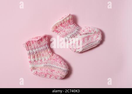 Kinderkleidung Konzept auf weißem Hintergrund. Pinke Strickschühchen. Isolieren Stockfoto