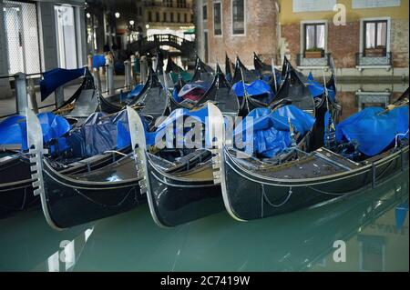 Europa, Italien, Venetien, Venedig. Stadt an der Adria-Lagune gebaut. Stadt der Wasserkanäle statt Straßen. Hauptstadt der Serenissima Republik Venedig. UNESCO-Weltkulturerbe Stationäre Gondeln bei Nacht Stockfoto