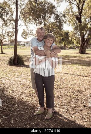 Porträt des kaukasischen älteren Ehepaares in den 70ern umarmt zeigt Liebe und Zuneigung im Park. Altern zusammen, Liebe, Ruhestand Lebensstil und zurück Stockfoto